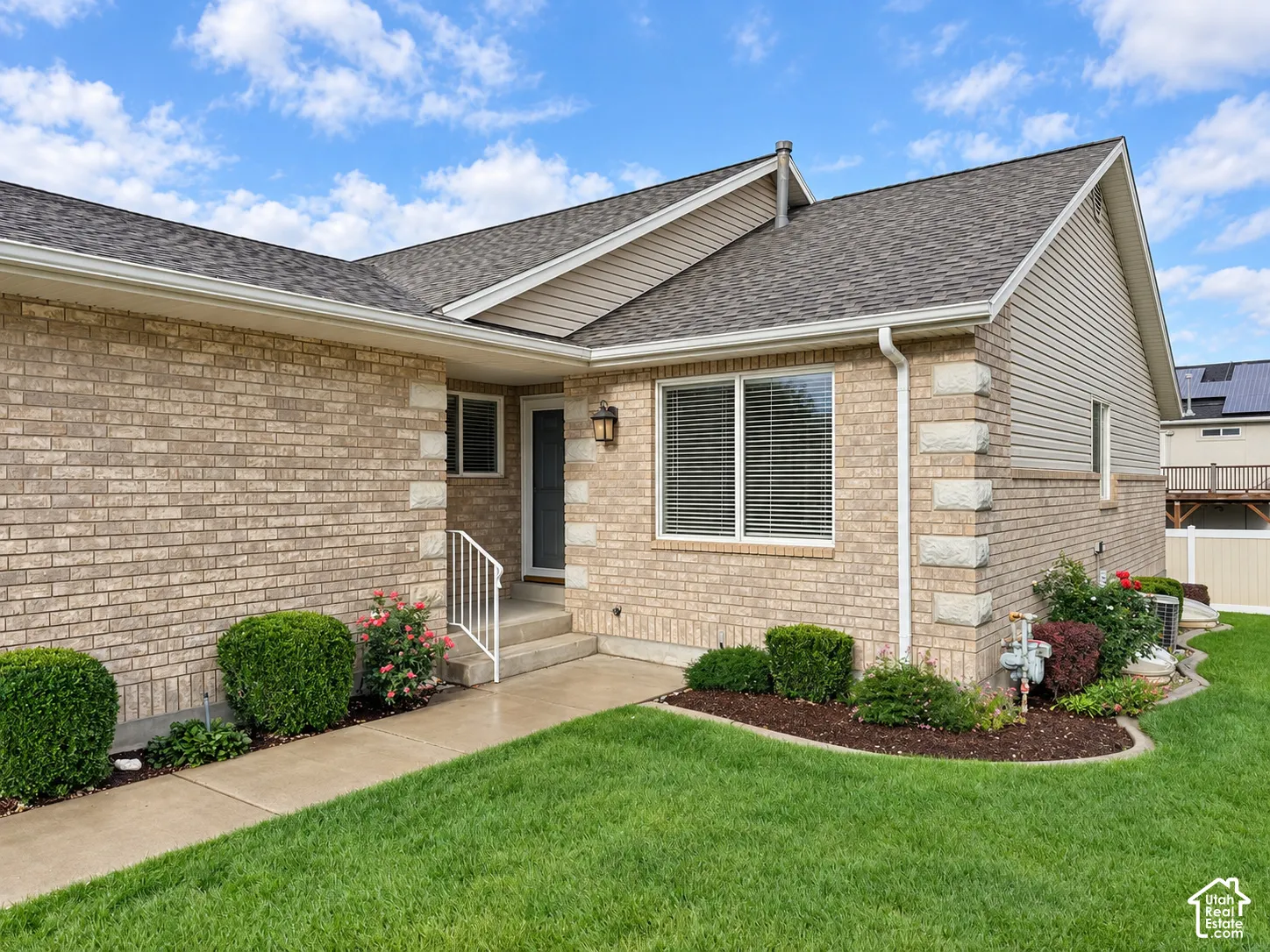 Brick exterior with stone accents, a gabled roof, and white-framed windows with blinds