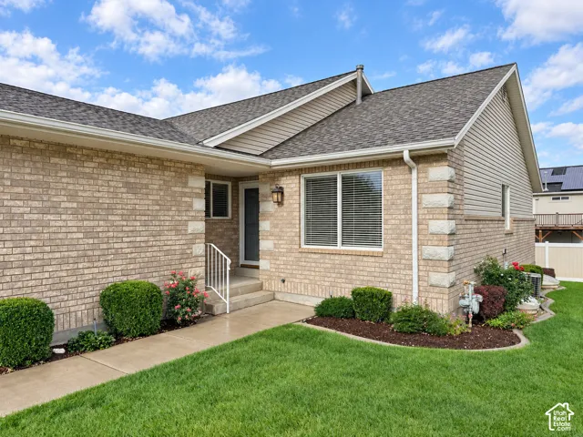 Brick exterior with stone accents, a gabled roof, and white-framed windows with blinds