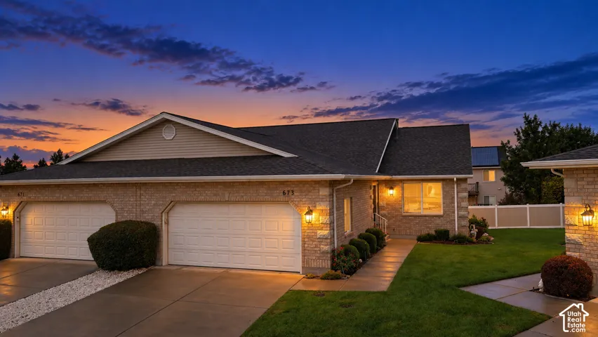 Brick exterior with a dark shingle roof and concrete driveway