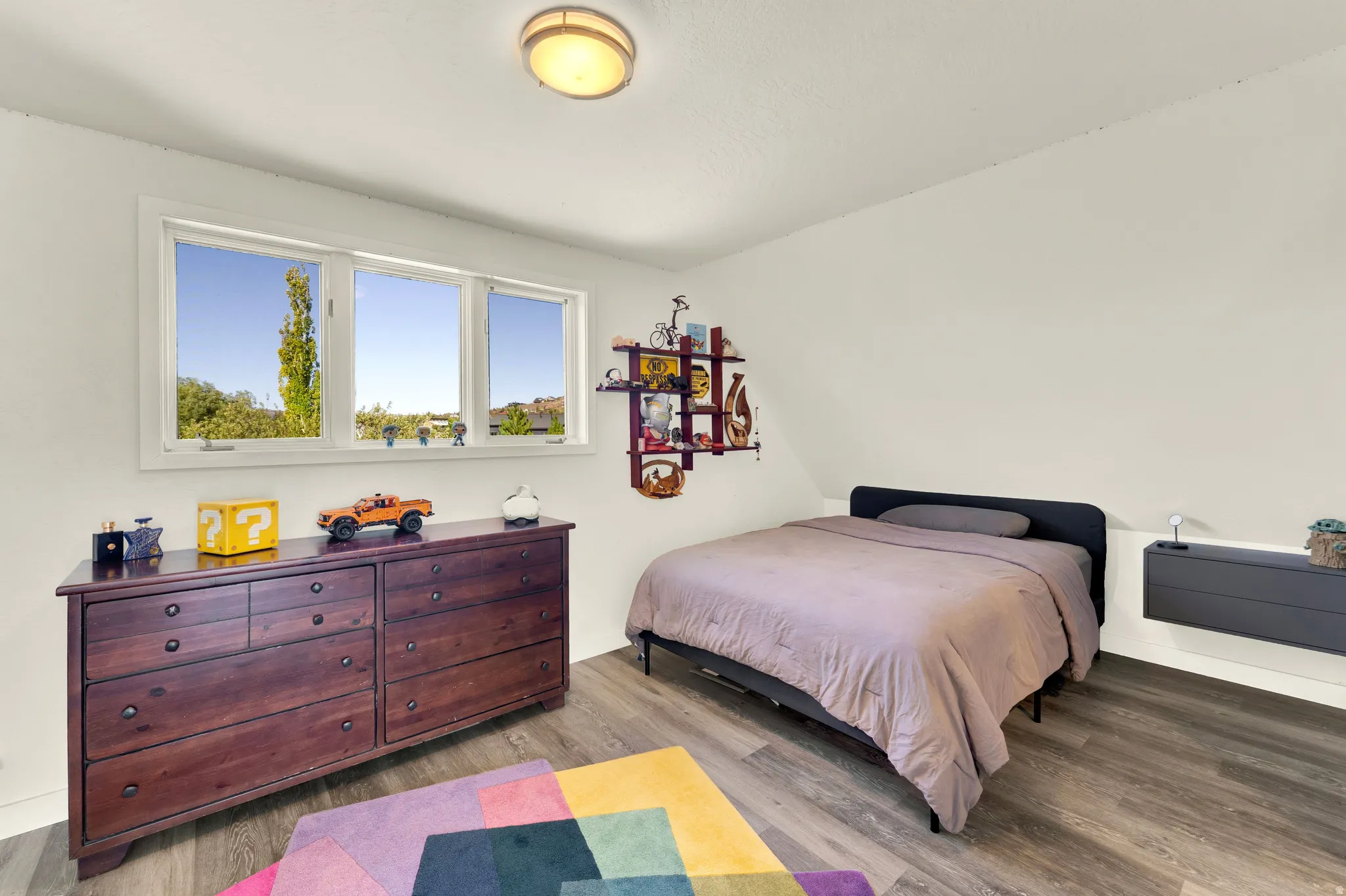 Wood-finish flooring, white walls, and a multi-pane window