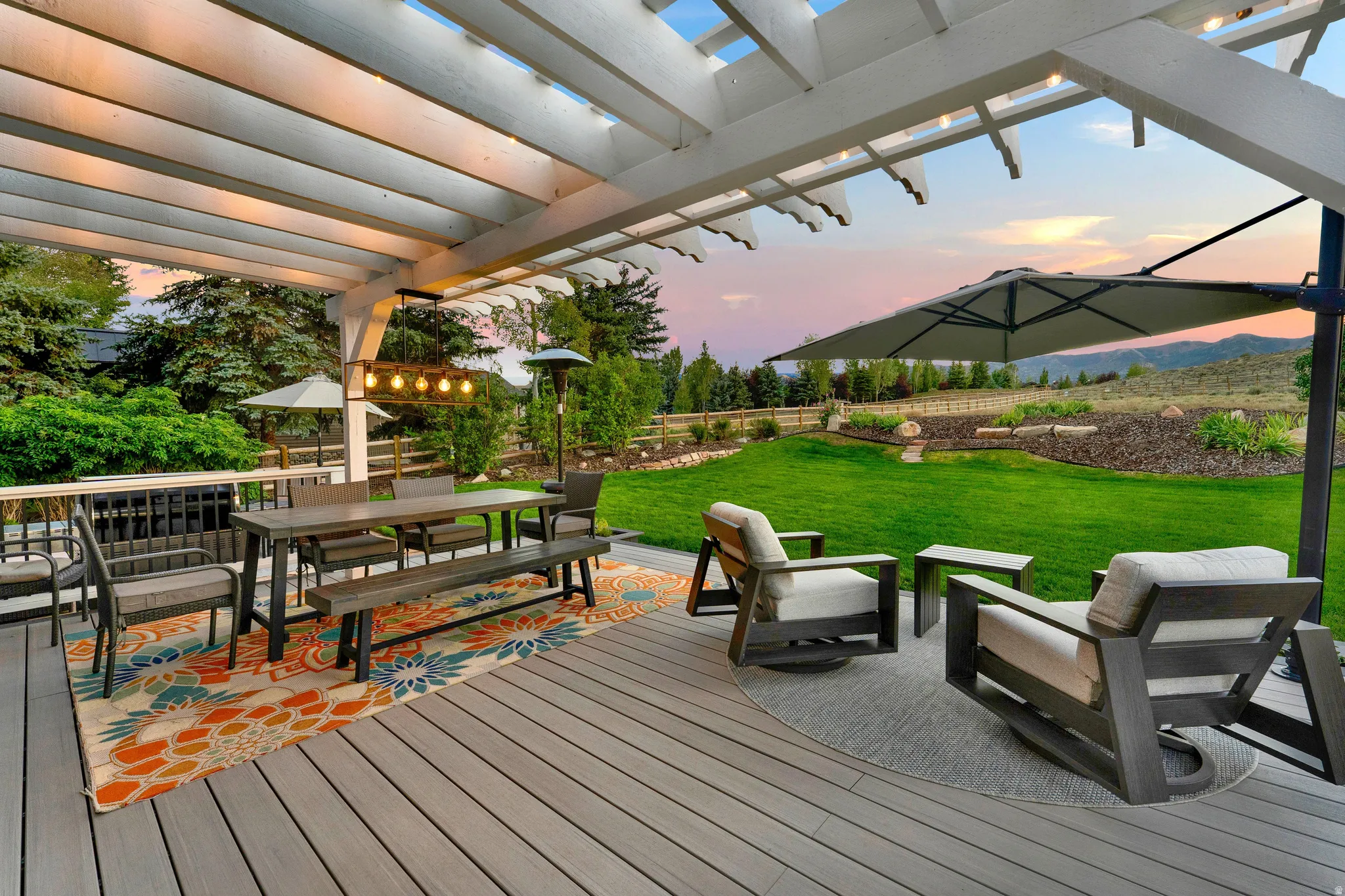 Expansive outdoor deck with a white wood pergola, providing covered outdoor living space