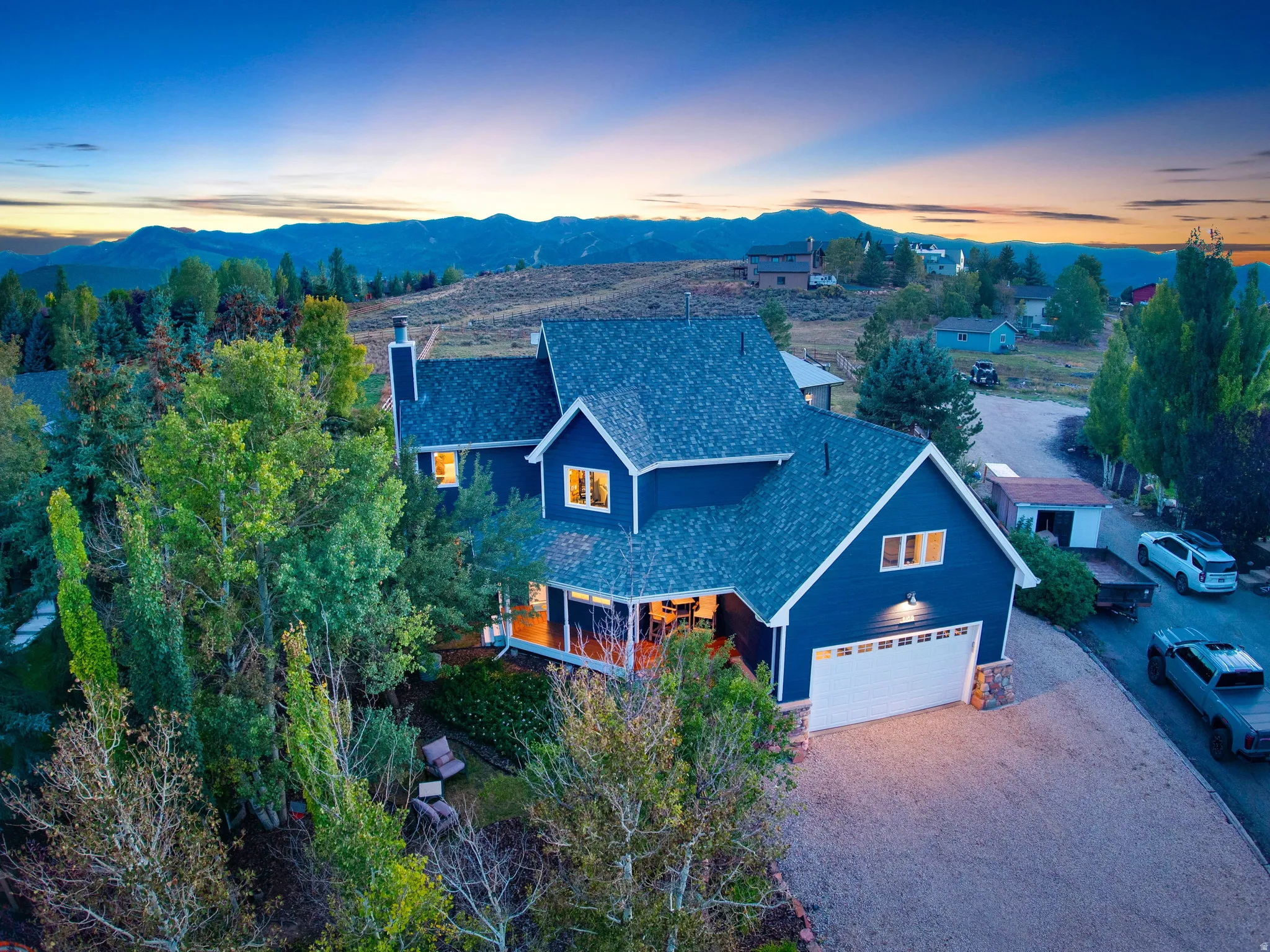 Blue exterior with white trim, attached garage, stone accents, and a covered porch