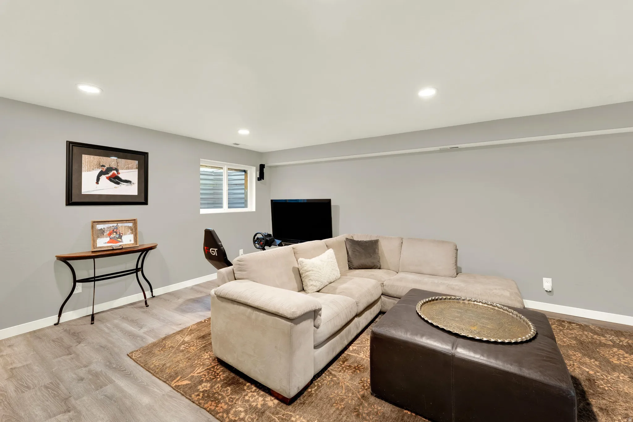 Recessed lighting, wood-finish flooring, light grey painted walls, and a window with horizontal blinds