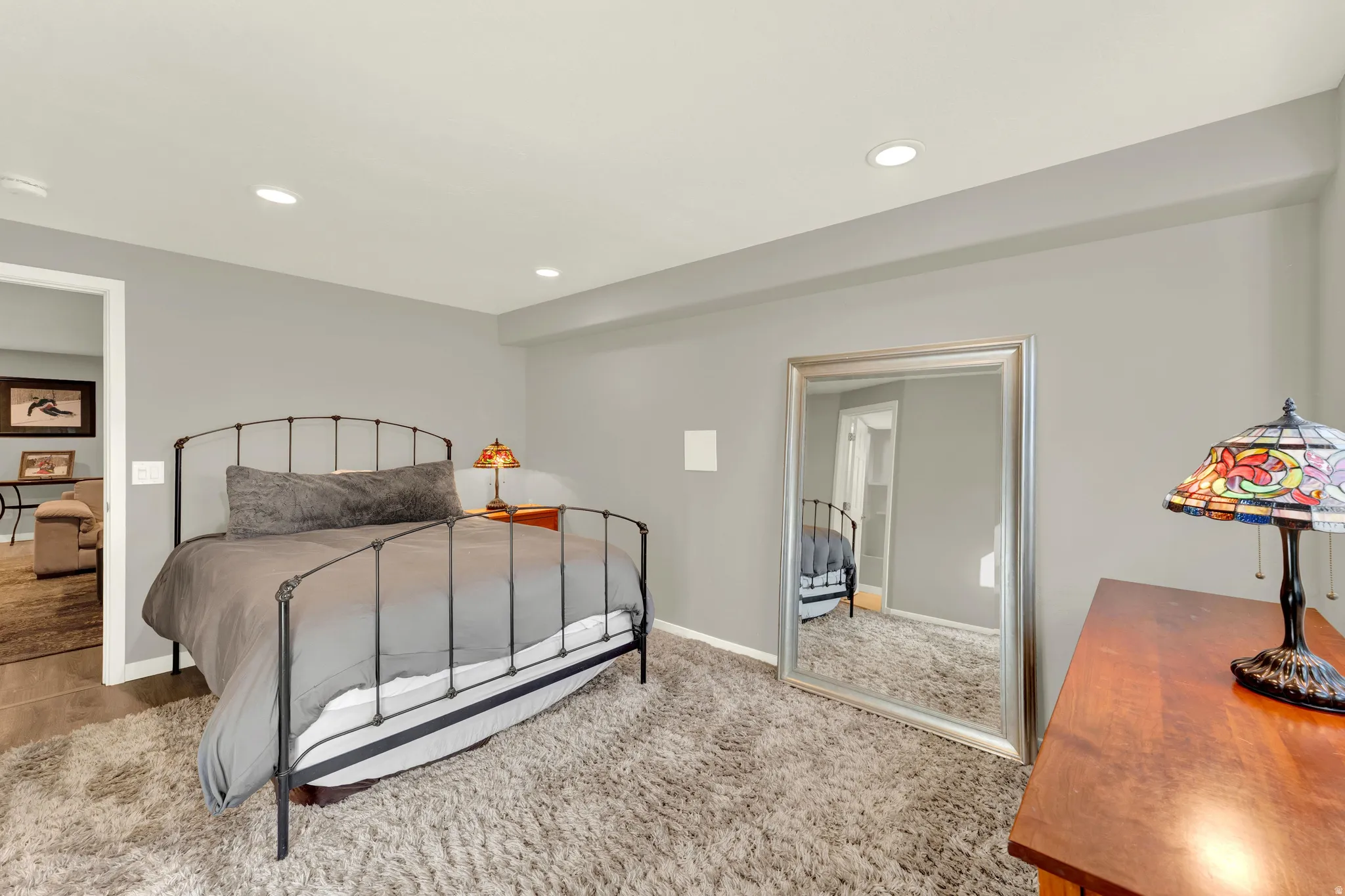 Recessed ceiling lighting, light gray wall paint, and gray textured carpet