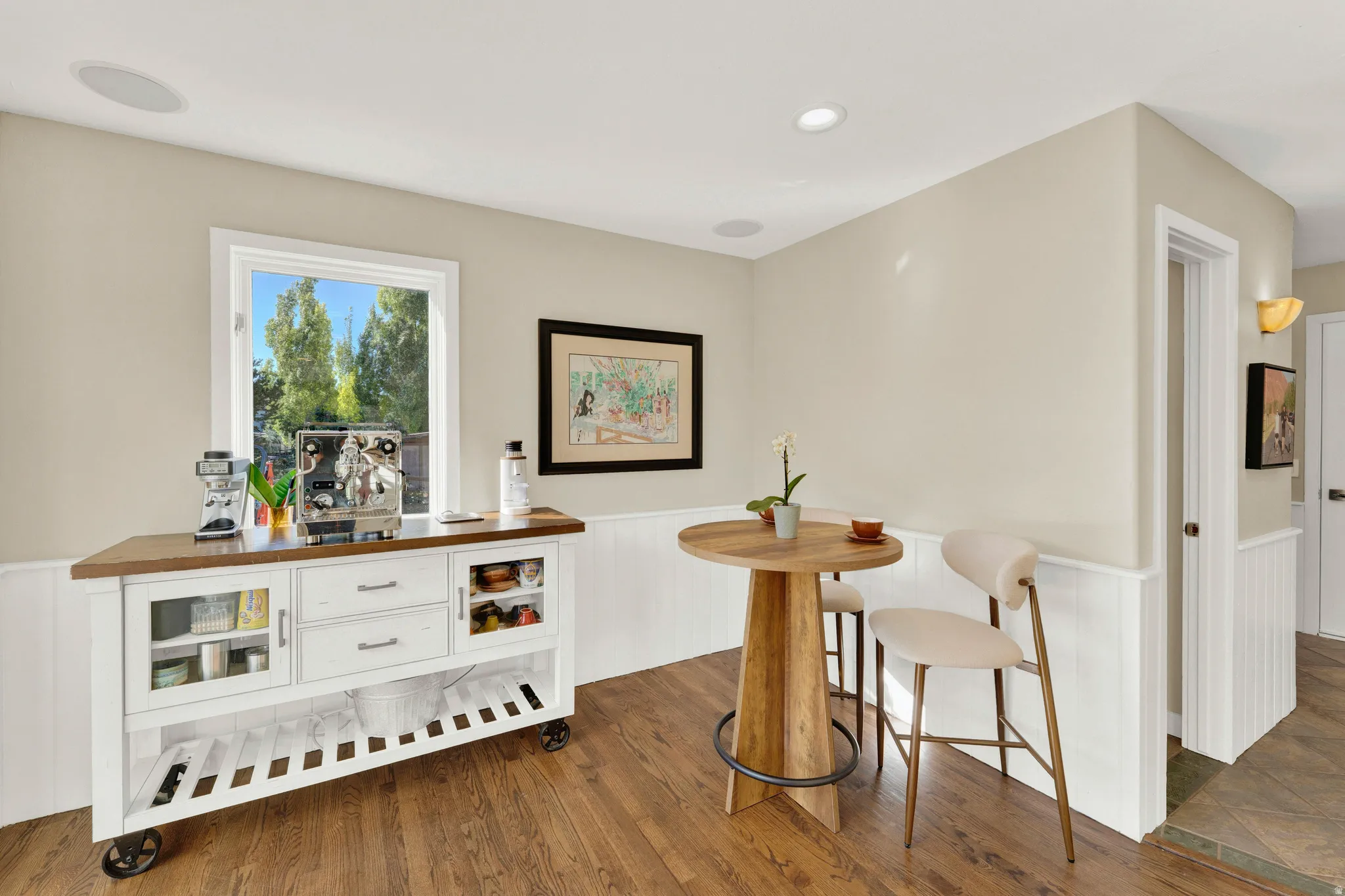 Wood-finish flooring with white wainscoting and neutral wall paint