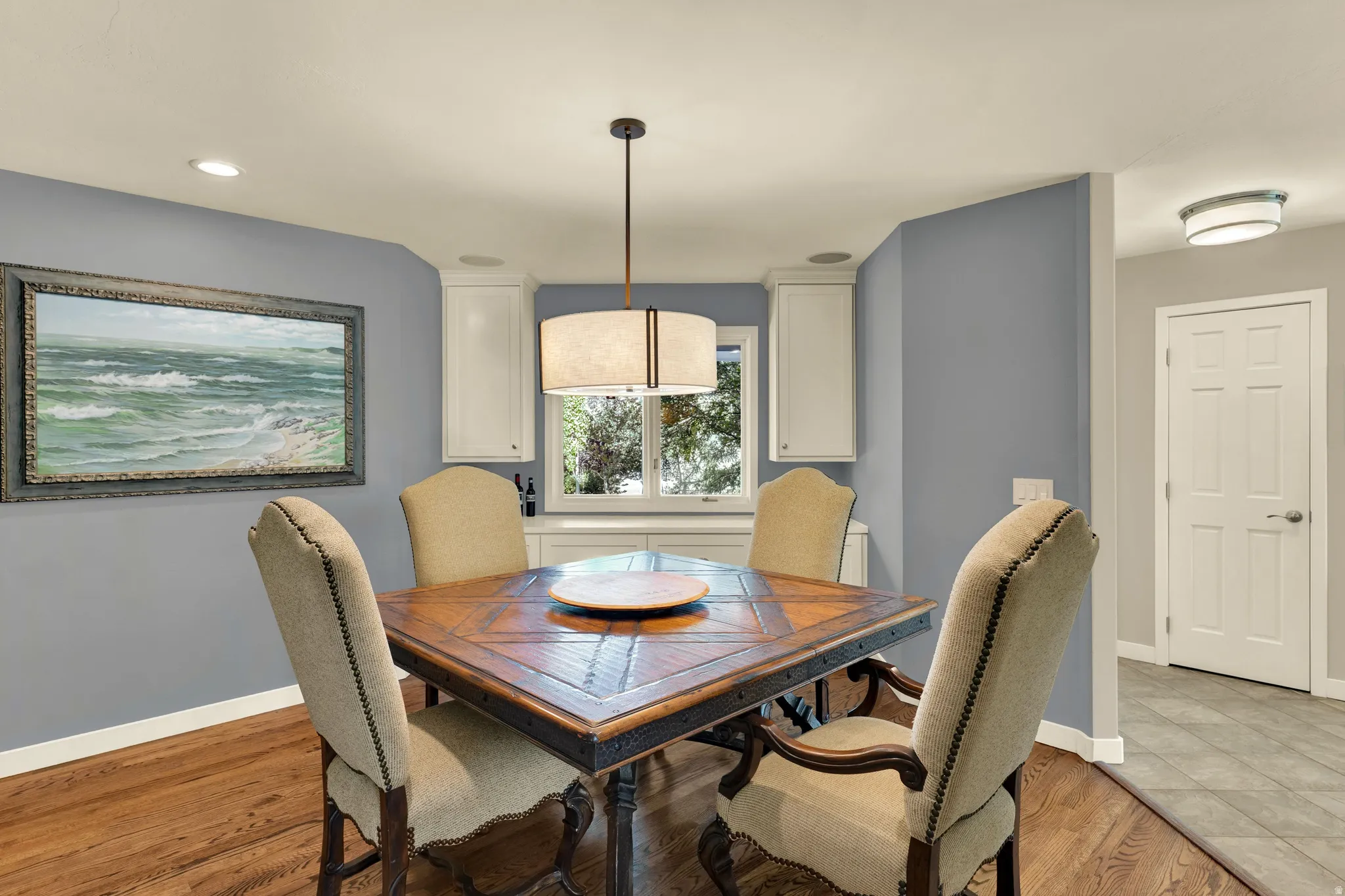 Hardwood flooring, recessed lighting, and white cabinetry