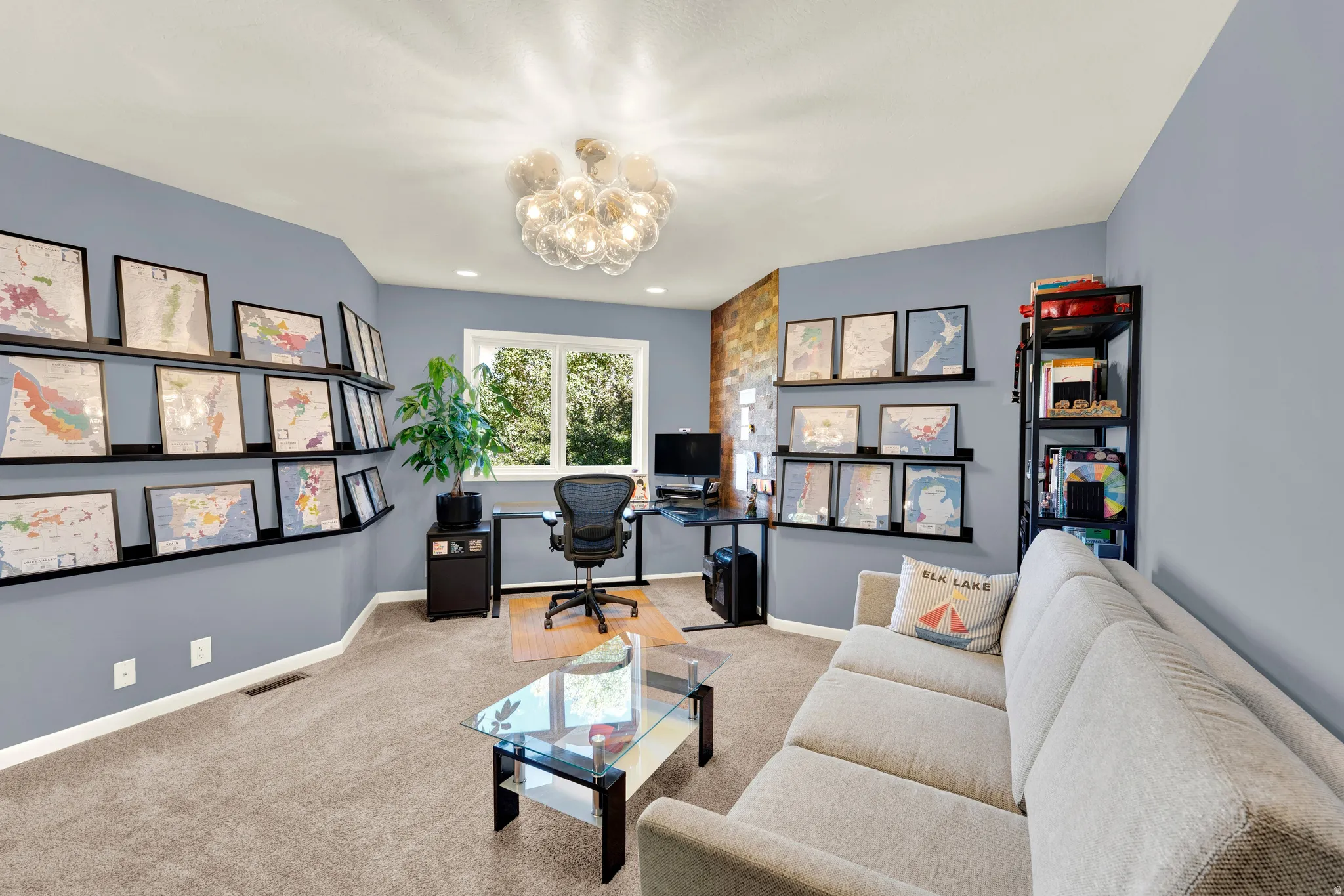 Recessed lighting and a decorative ceiling fixture illuminate this carpeted room, featuring a double window, wall-mounted shelving, and a built-in display shelf