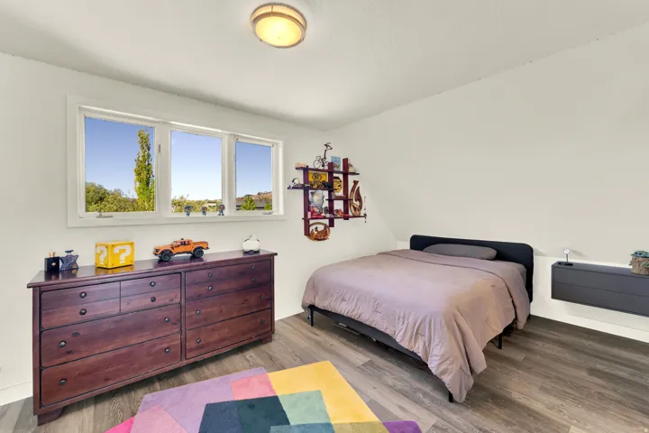 Wood-finish flooring, white walls, and a multi-pane window
