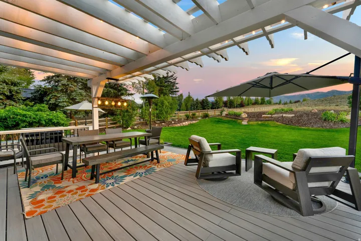 Expansive outdoor deck with a white wood pergola, providing covered outdoor living space