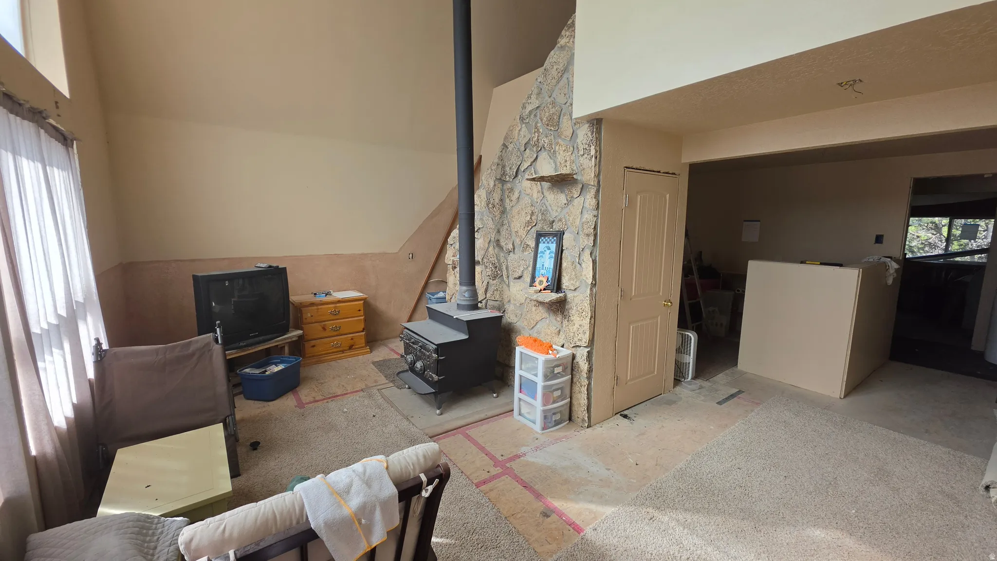 Stone-clad feature wall with wood-burning stove and a sloped ceiling