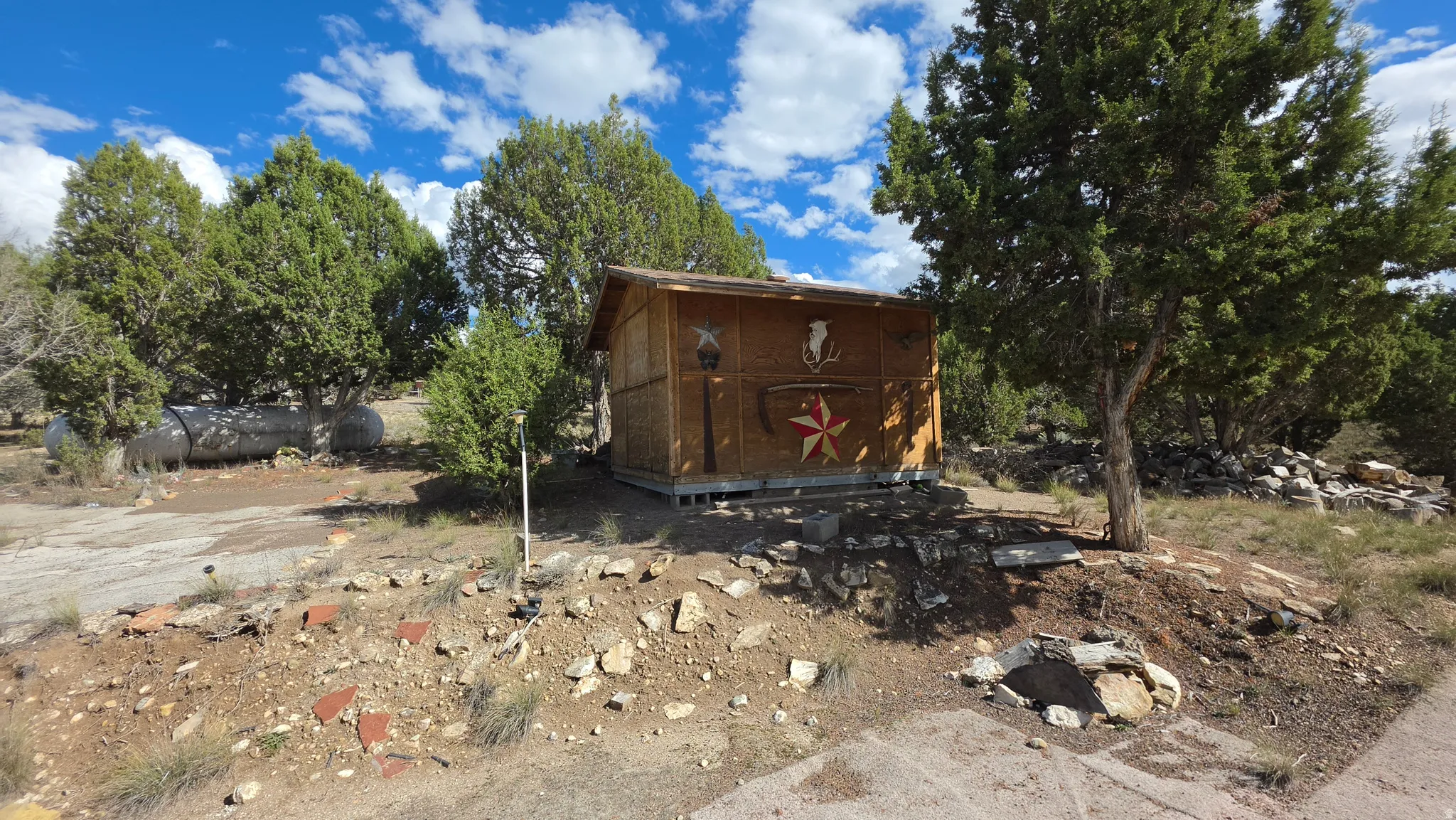 Wood-sided shed structure on a natural, rocky landscape