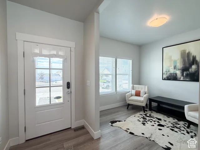 Entryway featuring a white door with window panes, wood-finish flooring, and a recessed ceiling light