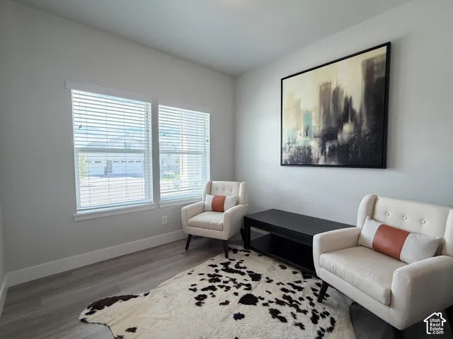 Light gray walls, wood-finish flooring, and white window blinds