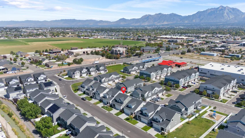 Residential community with mountain backdrop, surrounded by established infrastructure and open fields