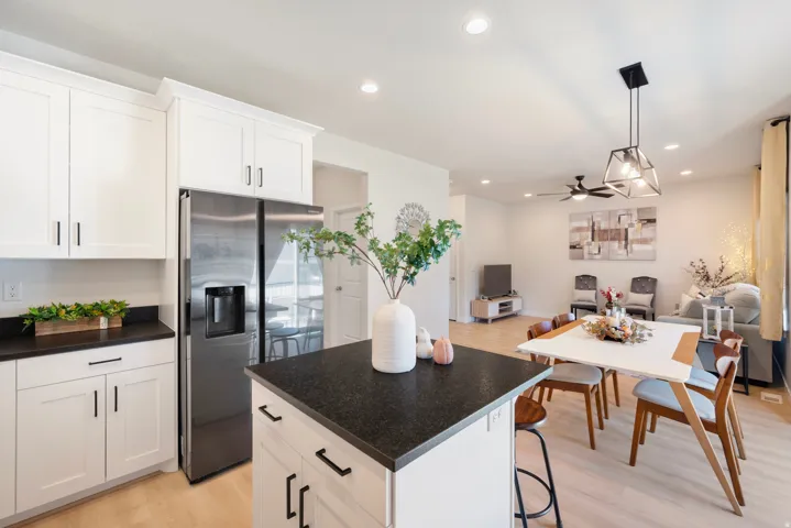 White shaker cabinetry with dark hardware and dark countertops