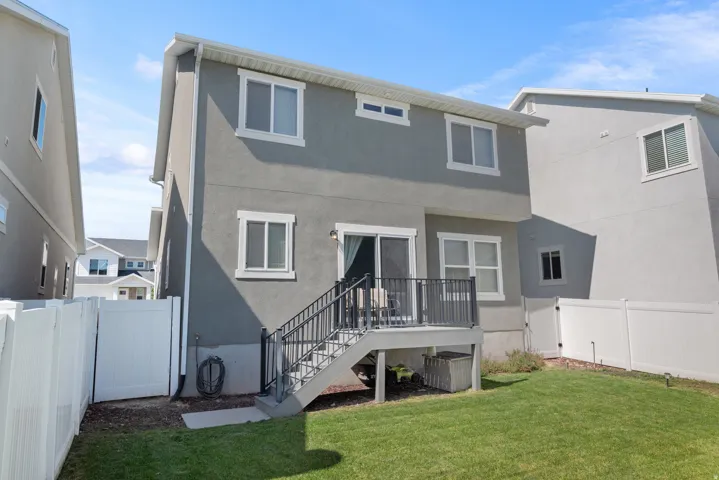 Private fenced yard with a ground-level patio, second-story balcony, and sliding glass door access