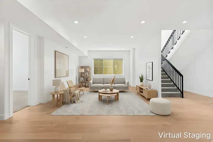 Recessed lighting, wood-finish flooring, white walls, and a staircase with black railings