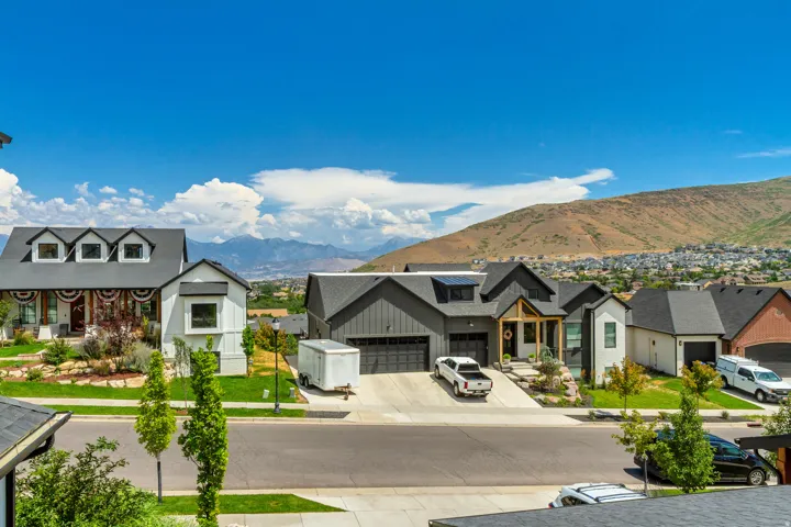 Modern residential architecture with varied exterior finishes, attached garages, and a mountain backdrop