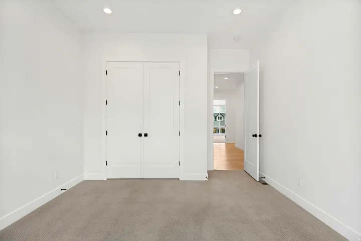 Recessed lighting, light-toned carpeting, white walls, and bright white trim