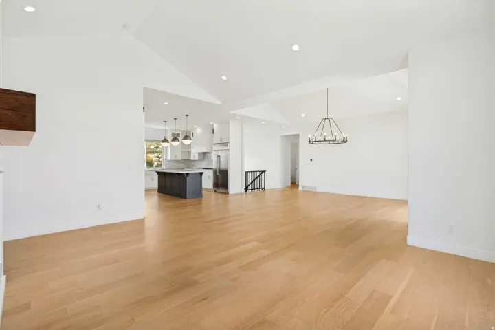 Vaulted ceilings with recessed lighting, wood-finish flooring, and an open-concept layout