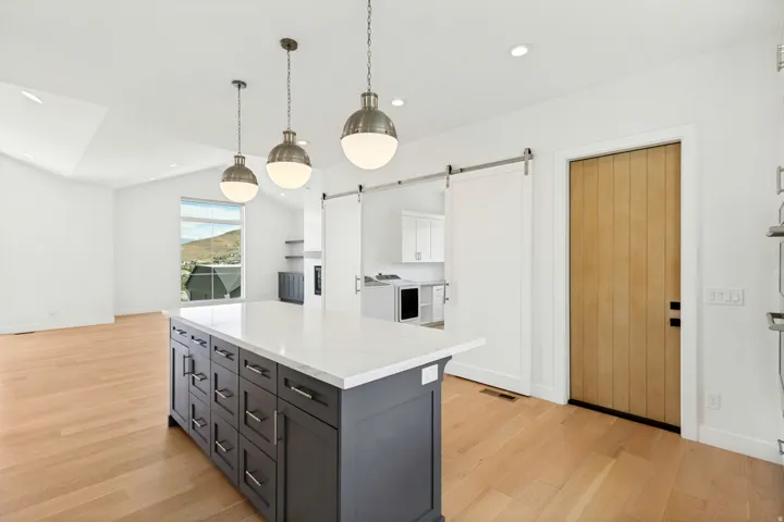 Central kitchen island with a light-toned countertop and dark cabinetry