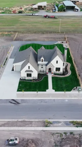 Two-story residence with a gray shingle roof and a combination of white siding and stone cladding