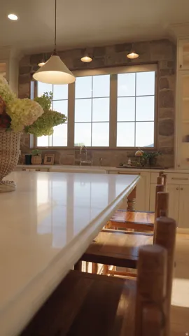 Central kitchen island with a polished countertop, surrounded by built-in cabinetry