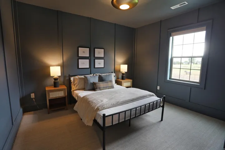 Dark paneled wall accents, carpeted flooring, and a single window with a white blind