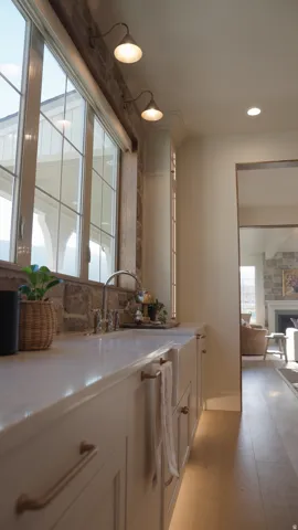 White cabinetry with gold-finish hardware, light wood-finish flooring, stone backsplash, and recessed lighting