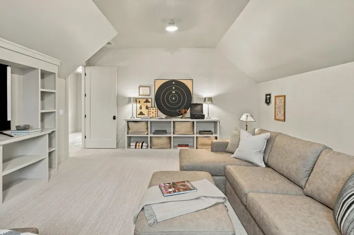 Recessed ceiling lighting, built-in shelving, vaulted ceilings, and a solid-panel interior door with dark hardware