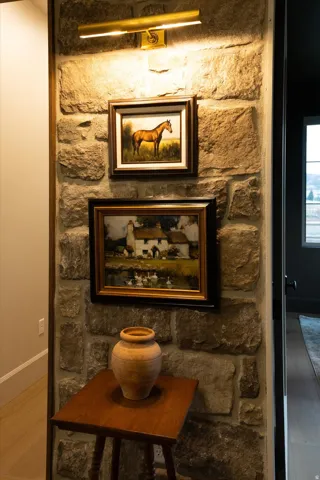 Stone accent wall with a brass picture light