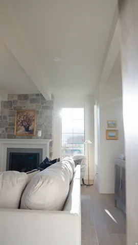Stone-clad fireplace with mantel, recessed lighting, and wood-finish flooring