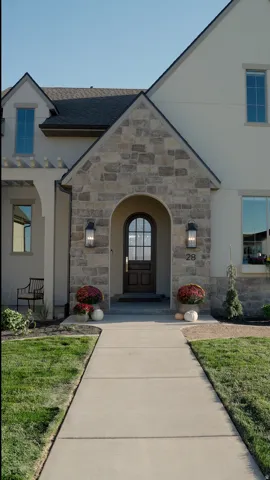 Stucco and stone exterior featuring an arched entryway