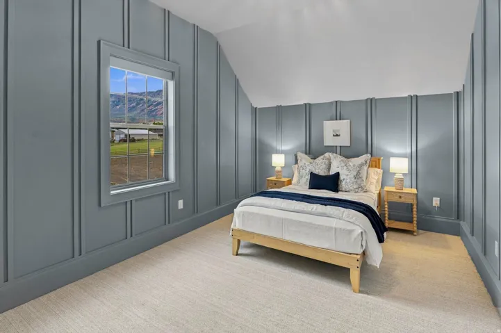 Board and batten wall treatment, light neutral carpeting, single window, sloped ceiling