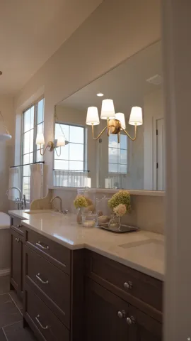 Dual vanity with wood-finish cabinetry, light-toned countertop, and integrated sinks