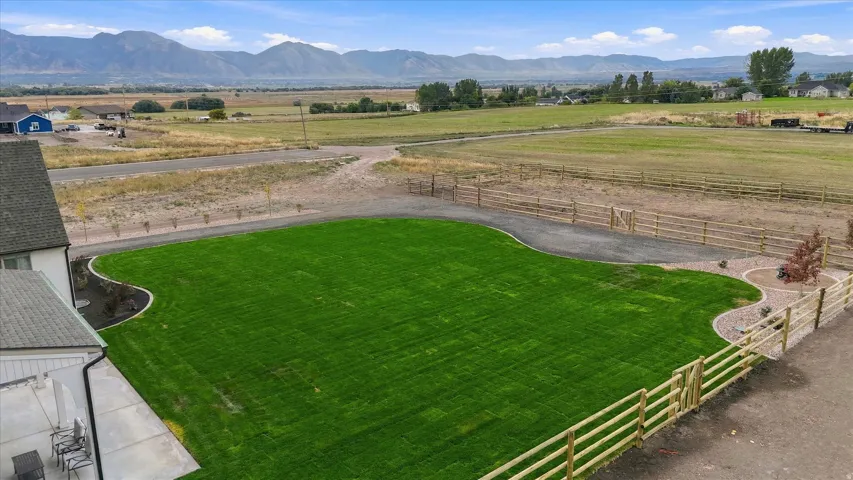 Expansive green lawn with defined landscaping borders and wood fencing