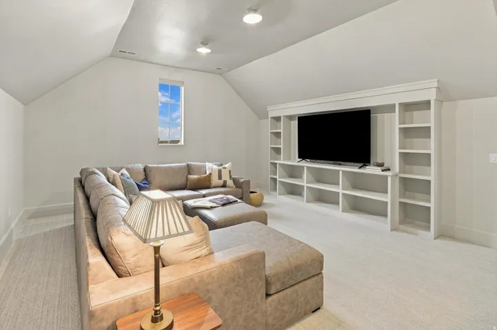 Carpeted room featuring a built-in media center with integrated shelving, recessed lighting, and an overhead window