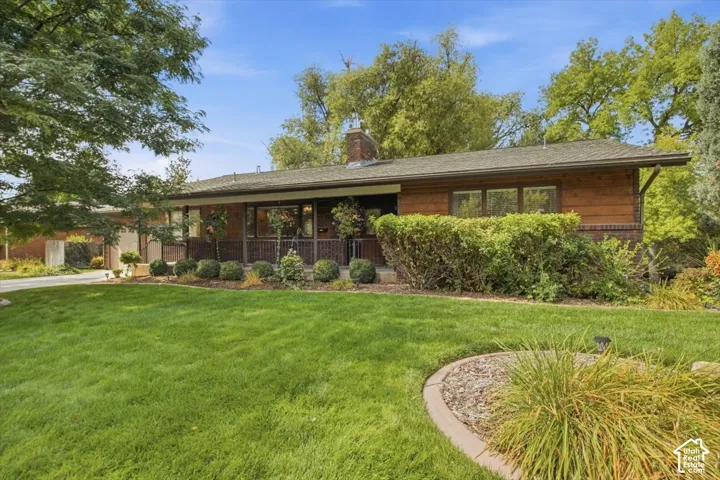 Ranch-style exterior with wood siding, brick accents, and a covered porch