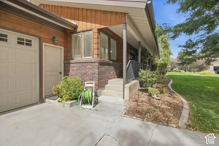Garage with carriage-style door, brick veneer, and wood siding