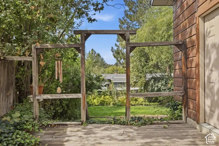 Wooden deck with an exposed wood frame and a natural wood-sided exterior
