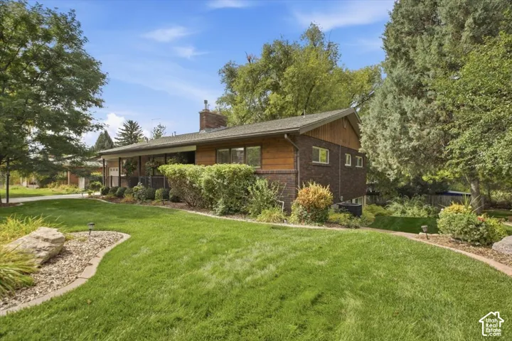 Brick exterior featuring wood siding accents and a pitched roofline