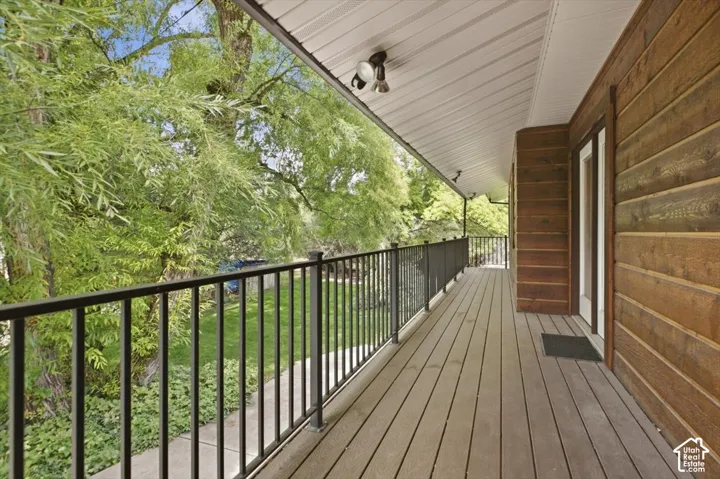 Extended outdoor deck featuring wood-finish planks and black metal railings