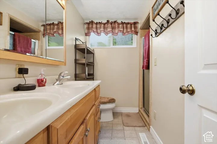 Double vanity with integrated sinks, wood-finish cabinetry, and single-handle chrome faucets