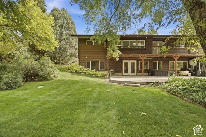 Expansive grassy yard with mature trees and established landscaping