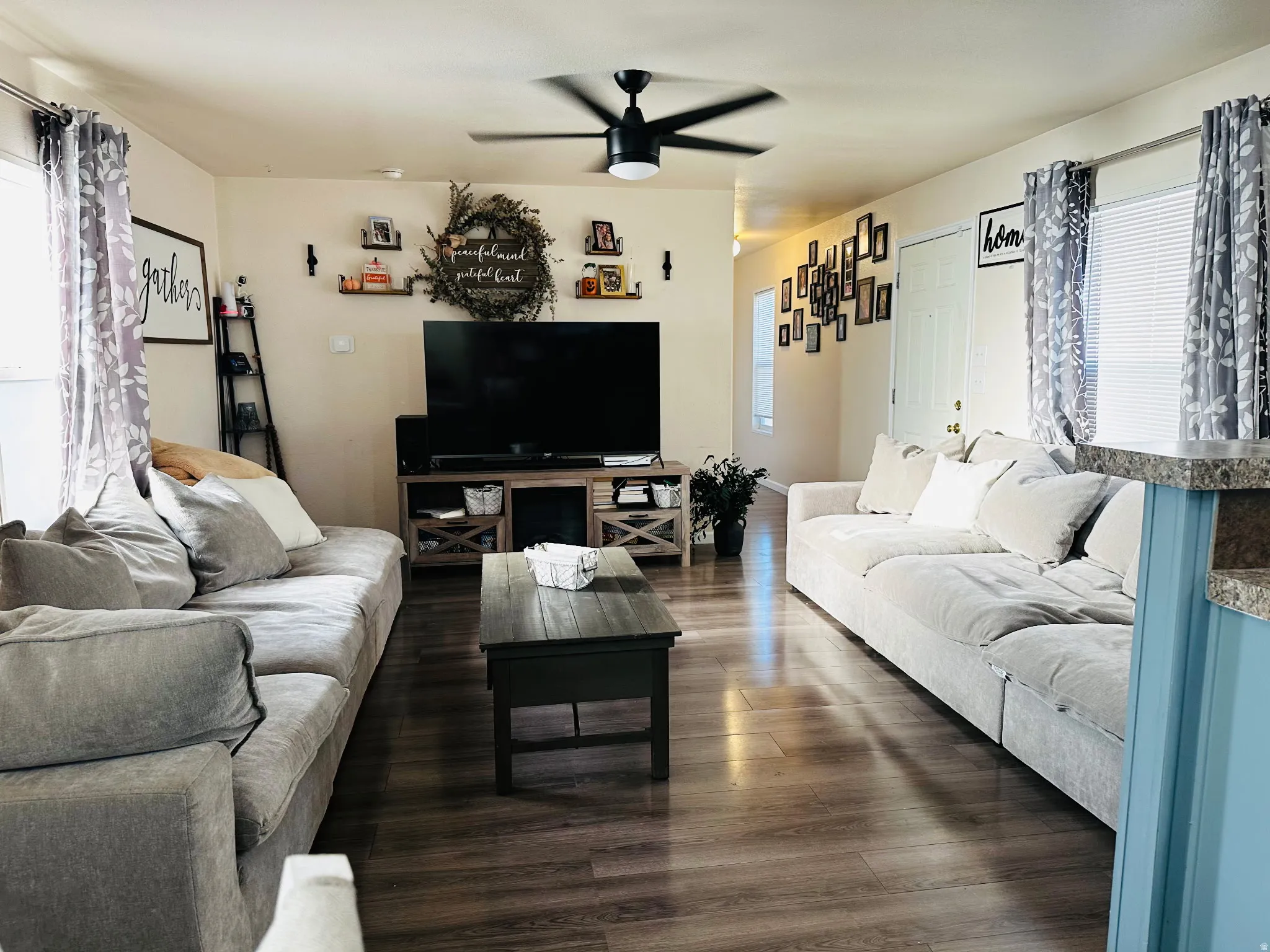 Wood-finish flooring throughout, ceiling fan, white paneled door, and recessed lighting