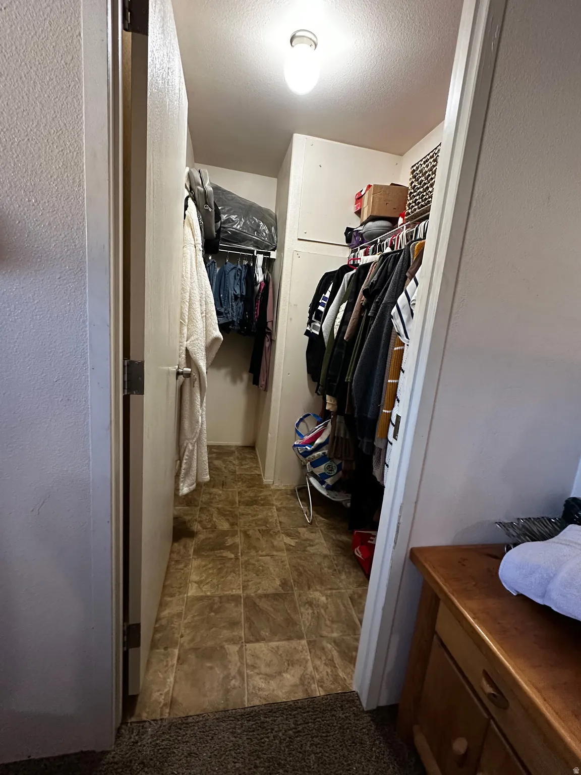 Walk-in closet with vinyl flooring, overhead lighting, and built-in shelving