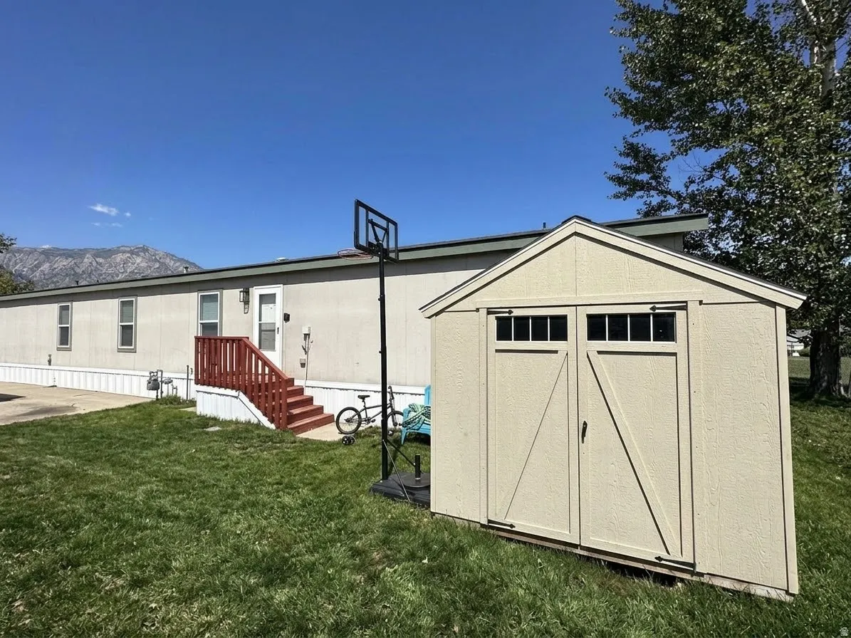 Exterior storage shed with double barn doors, transom windows, and an exterior entry with red-painted steps