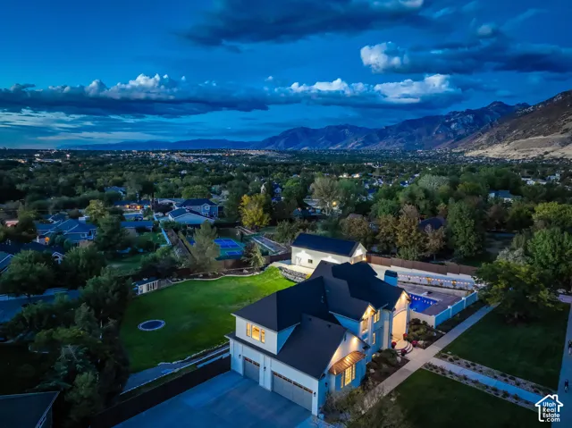 Expansive property featuring a multi-car garage, manicured lawn, and a swimming pool with surrounding hardscaping