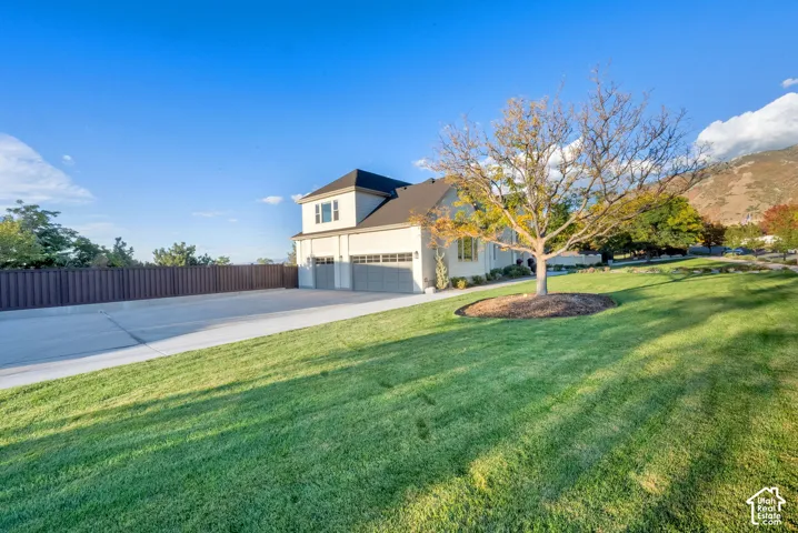 Contemporary residence with a dark shingled roof, light-colored siding, and a two-story architectural element