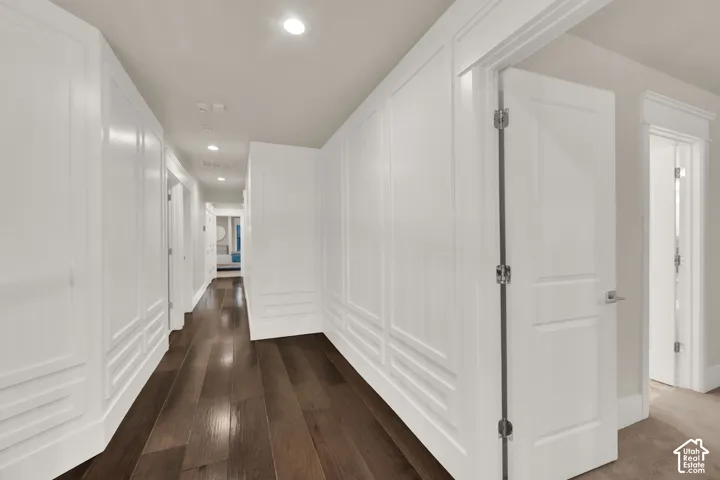 Hardwood flooring, recessed lighting, white paneled walls, white trim, interior doors with lever handles